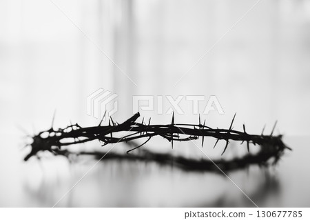 Crown of thorns on white table background. Easter, central celebration in Christianity, honors sacrifice of Jesus Christ, crown of thorns symbolizes redemption, faith, deep spirituality of religion. Crown of thorns on white table background. Easter, central celebration in Christianity, honors sacrifice of Jesus Christ, crown of thorns symbolizes redemption, faith, deep spirituality of religion. 130677785
