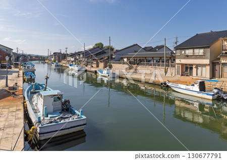 Houses lined up along the river and moored fishing boats Houses lined up along the river and moored fishing boats 130677791