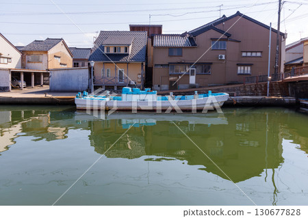 Houses lined up along the river and moored fishing boats 130677828