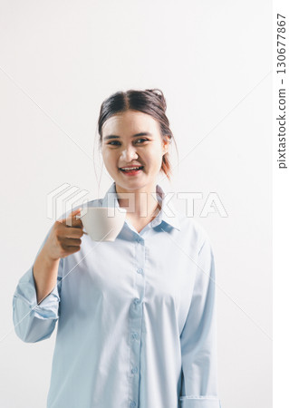 Asian woman rejoicing, looking happy, champion, fist pump gesture, standing over white background. young woman had happy, positive expression on her face, highlighted by bright smile. 130677867