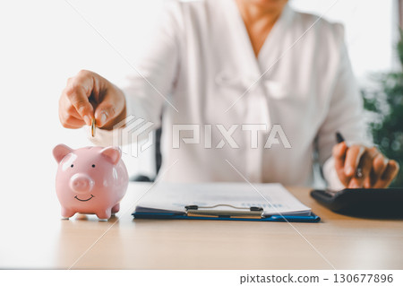 Businesswoman focused on saving money, smart financial planning, using banking, investment strategies to grow business, build wealth, achieve success while contributing to overall economy growth. Businesswoman focused on saving money, smart financial planning, using banking, investment strategies to grow business, build wealth, achieve success while contributing to overall economy growth. 130677896