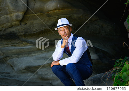 A man in a suit standing in a sea cave. A business image symbolizing challenge and determination. 130677963