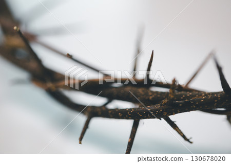 Crown of thorns on white table background. Easter, central celebration in Christianity, honors sacrifice of Jesus Christ, crown of thorns symbolizes redemption, faith, deep spirituality of religion. 130678020