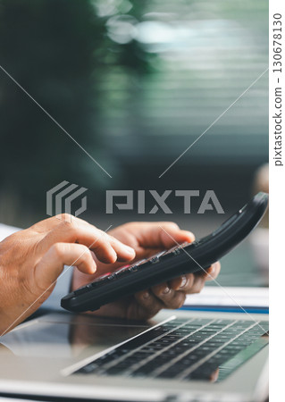 Businesswoman at table, calculator, monthly tax calculations, budgeting, managing expenses-illustrating business, finance, accounting, banking concept essential for effective budget management. Businesswoman at table, calculator, monthly tax calculations, budgeting, managing expenses-illustrating business, finance, accounting, banking concept essential for effective budget management. 130678130
