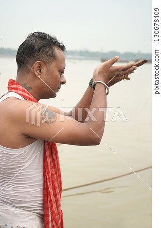Man Performing a Religious Ritual of Tarpan during Mahalaya Morning at Babughat Ganga Ghat Man Performing a Religious Ritual of Tarpan during Mahalaya Morning at Babughat Ganga Ghat 130678409