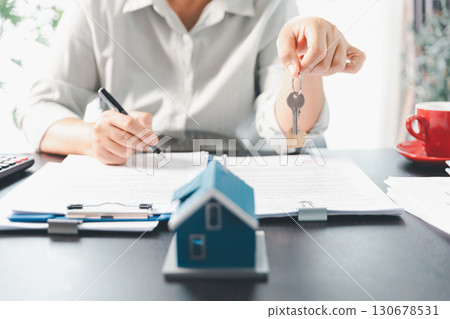 Real estate agent agree to buy home to clients agency office. House model, real estate agent, customer discussing for contract to buy house, insurance, loan real estate background. Concept agreement. Real estate agent agree to buy home to clients agency office. House model, real estate agent, customer discussing for contract to buy house, insurance, loan real estate background. Concept agreement. 130678531