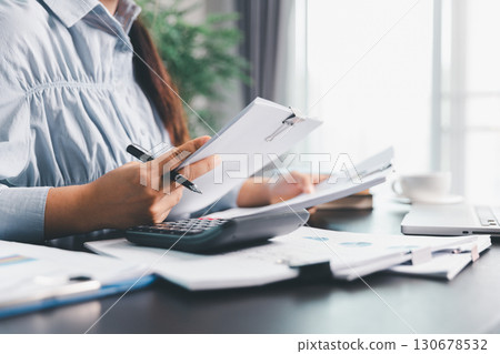 Business woman analyze calculate company financial, tax results office accounting statistics analytical research. calculating business balance prepare tax reduction. Tax deduction planning concept. Business woman analyze calculate company financial, tax results office accounting statistics analytical research. calculating business balance prepare tax reduction. Tax deduction planning concept. 130678532