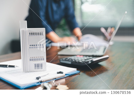 Female hand holds small miniature toy house, symbolizing woman dream of moving into her own home-real estate concept represents property investment, mortgage planning, insurance for secure future. 130678536