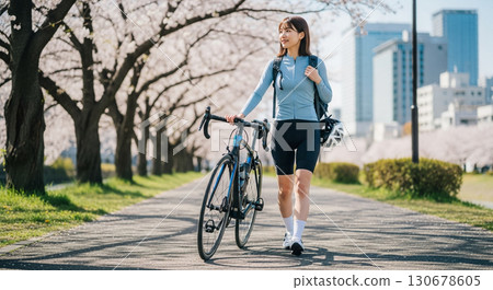A young woman walking with a road bike 130678605