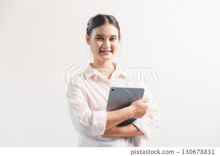 Asian woman rejoicing, looking happy, champion, fist pump gesture, standing over white background. young woman had happy, positive expression on her face, highlighted by bright smile. 130678831