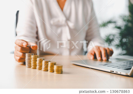 Hand places coin into saving jar, representing how smart finance, investment, banking practices turn money, cash, currency into financial wealth drives business growth and strengthens the economy. 130678863