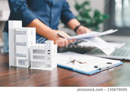 Female hand holds small miniature toy house, symbolizing woman dream of moving into her own home-real estate concept represents property investment, mortgage planning, insurance for secure future. Female hand holds small miniature toy house, symbolizing woman dream of moving into her own home-real estate concept represents property investment, mortgage planning, insurance for secure future. 130679098
