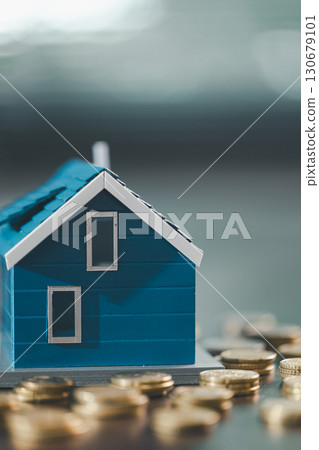 House model placed beside money coins illustrates concept of saving and financial planning for buying home, highlighting investment, mortgage options, home loans, refinancing, smart finance strategies 130679101