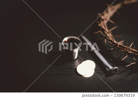 Holy Bible with communion bread, wine, crown of thorns and crucifixion nail symbolizing the sacrifice of Jesus Christ, His suffering, crucifixion and salvation through the cross. 130679319