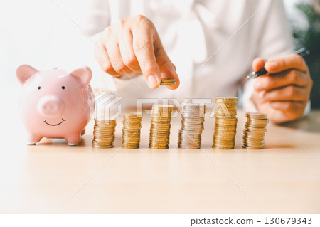 Businesswoman focused on saving money, smart financial planning, using banking, investment strategies to grow business, build wealth, achieve success while contributing to overall economy growth. 130679343