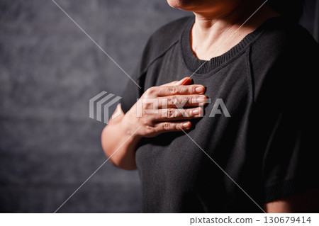 Christian woman lifts her hand in worship to pray, hope, faith, and deep belief in God defines core concept of religion. Praying hands with faith in religion, belief in God. Power of hope or love. 130679414