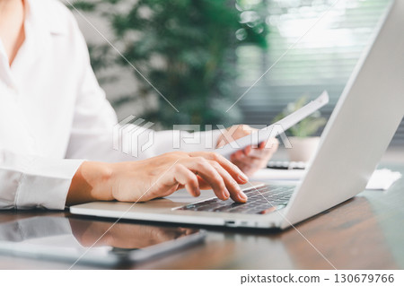 Businesswoman manages finances by using banking and accounting system to calculate costs, taxes, investments, illustrating a business, finance, and real estate concept focused on financial strategy. 130679766