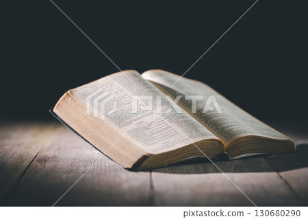 Hands clasped in prayer over the holy Bible, the faithful Christian worships God in church, holding onto hope and belief, guided by religion and a deep commitment to their religious faith. Hands clasped in prayer over the holy Bible, the faithful Christian worships God in church, holding onto hope and belief, guided by religion and a deep commitment to their religious faith. 130680290