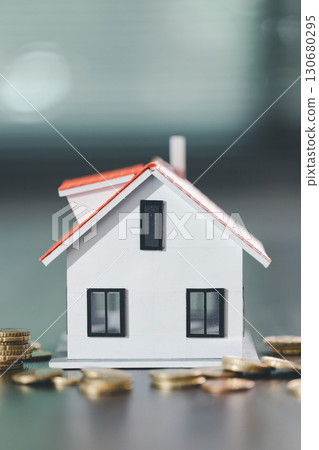 House model placed beside money coins illustrates concept of saving and financial planning for buying home, highlighting investment, mortgage options, home loans, refinancing, smart finance strategies 130680295
