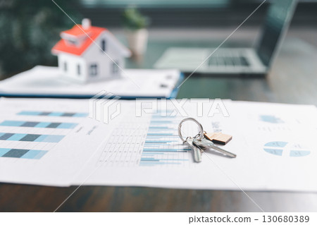House model placed on table alongside coins, paperwork symbolizes real estate investment, property valuation, representing financial planning, mortgage options, market analysis in property business. House model placed on table alongside coins, paperwork symbolizes real estate investment, property valuation, representing financial planning, mortgage options, market analysis in property business. 130680389