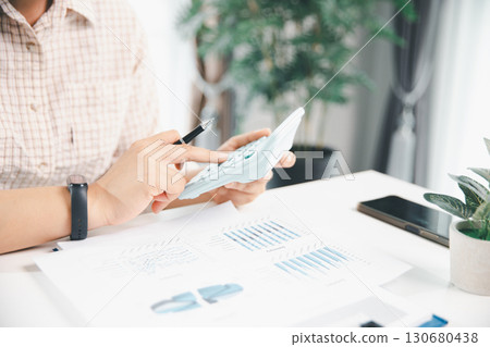 Accountant working on desk using calculator for calculate finance report in office. business finance, calculate tax by organizing financial documents, tracking income investment, accounting by hand. Accountant working on desk using calculator for calculate finance report in office. business finance, calculate tax by organizing financial documents, tracking income investment, accounting by hand. 130680438