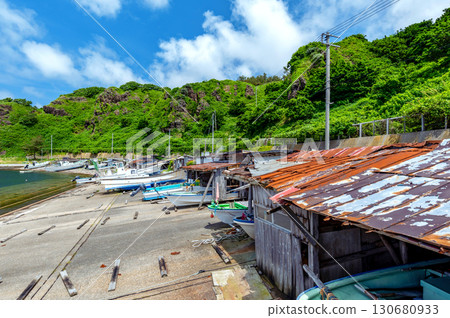 [Henashi Fishing Port, Fukaura Town, Aomori Prefecture] A view of a quaint fishing port lined with small boathouses 130680933