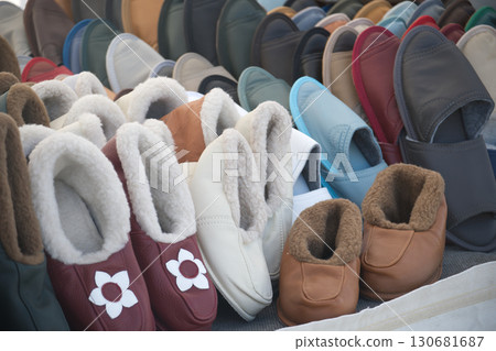 A colorful array of cozy sheepskin slippers, perfect for relaxed indoor comfort, are on display. 130681687