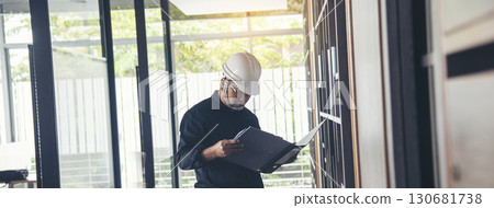 Man construction engineer writing note wear blue shirt safety white hard hat at construction site. Industry labour male worker. Architecture man drawing engineer civil constrcution real estate 130681738