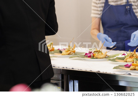 French chef, close-up of hands serving food, work scene 130682025