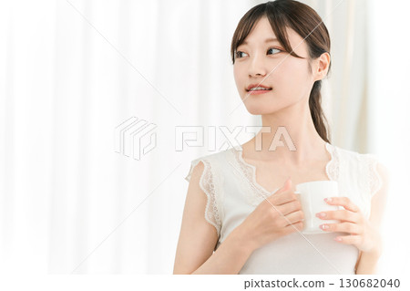 微笑的亞洲女性早上在家喝熱水、咖啡、熱飲、牛奶咖啡和拿鐵咖啡 微笑的亞洲女性早上在家喝熱水、咖啡、熱飲、牛奶咖啡和拿鐵咖啡 130682040