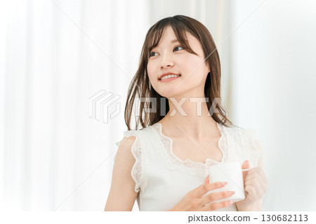 微笑的亞洲女性早上在家喝熱水、咖啡、熱飲、牛奶咖啡和拿鐵咖啡 130682113