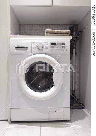 Laundry room in house. Washing machine and linen storage cabinet. Cleanliness and lifestyle. Activities, house cleaning. 130682326