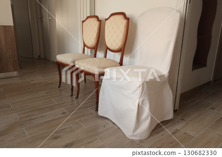 Renewal of old vintage furniture. Chairs and white covers. Interior design in apartment. 130682330