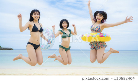 三位身穿比基尼的女子在美麗的大海中跳躍 130682404
