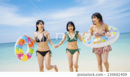 三位穿著比基尼的女子在美麗的大海中玩耍 三位穿著比基尼的女子在美麗的大海中玩耍 130682409