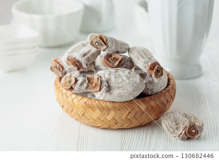Dried persimmons on a white wooden table. 130682446