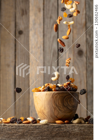 Mix of dried nuts and raisins on a wooden table. 130682466