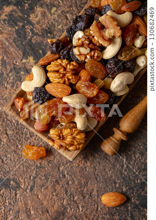 Mix of nuts and raisins on a brown rustic background. 130682469