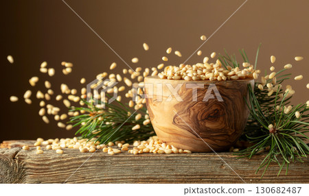 Flying peeled pine nuts on a brown background. Flying peeled pine nuts on a brown background. 130682487