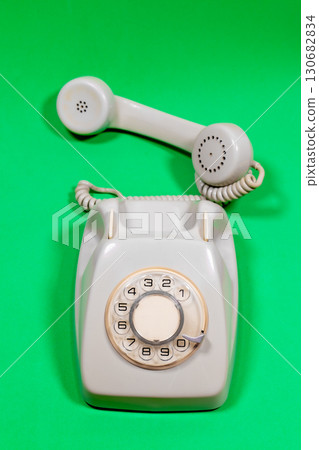 A antique roulette phone on a green surface. 130682834