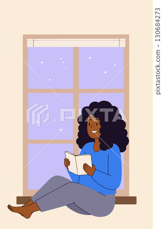 Woman Reading by Window on Snowy Day 130684273