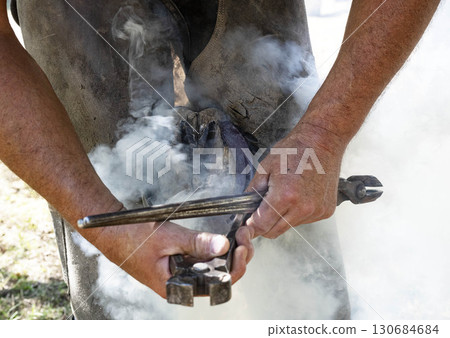 Farrier works in a field Farrier works in a field 130684684