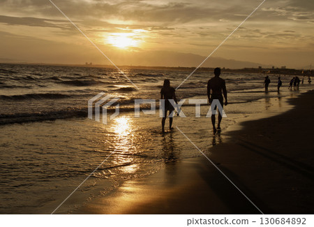 Walking on the beach in the sunset 130684892
