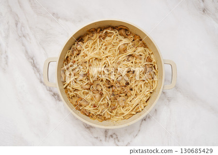 Overhead view of large pot with cooked noodles and creamy mushroom sauce Overhead view of large pot with cooked noodles and creamy mushroom sauce 130685429