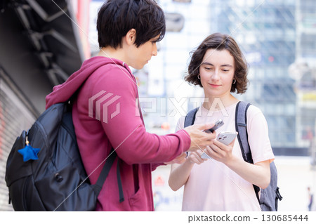 Inbound: Foreigners strolling around the streets of Tokyo while looking at their smartphones 130685444