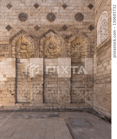Exterior wall of the Mosque of al-Zahir Baybars, Cairo, Egypt, featuring Mamluk stone carvings and arches 130685732