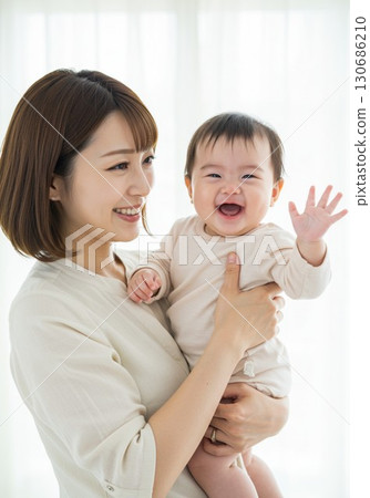 母親微笑著抱著孩子,享受快樂的親子時光 母親微笑著抱著孩子,享受快樂的親子時光 130686210