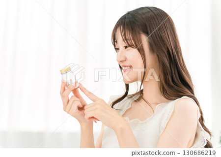 A smiling Asian woman checking the ingredients of medicines and supplements 130686219