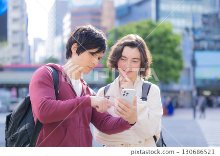 Inbound: Foreigners strolling around the streets of Tokyo while looking at their smartphones Inbound: Foreigners strolling around the streets of Tokyo while looking at their smartphones 130686521