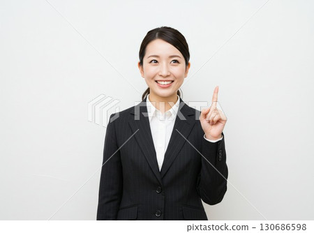 一位穿著西裝、舉起手指解釋的商業圖片 一位穿著西裝、舉起手指解釋的商業圖片 130686598